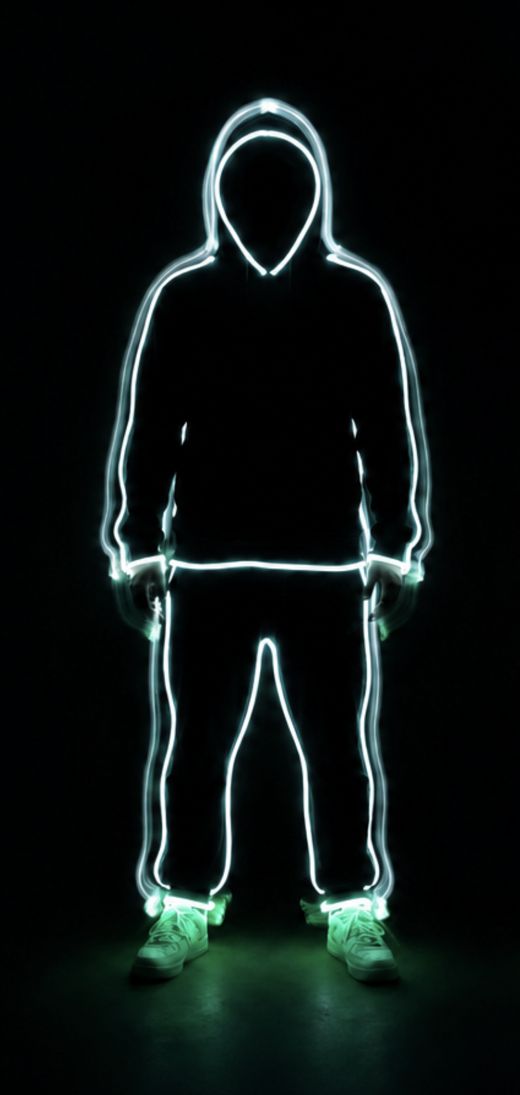 Front-facing glowing wireframe figure in a hoodie and pants against a black background, with green-glowing sneakers.